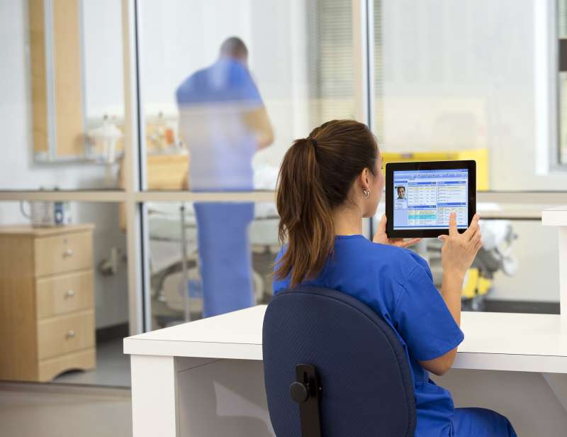 Physician Assistant using a tablet in a hospital