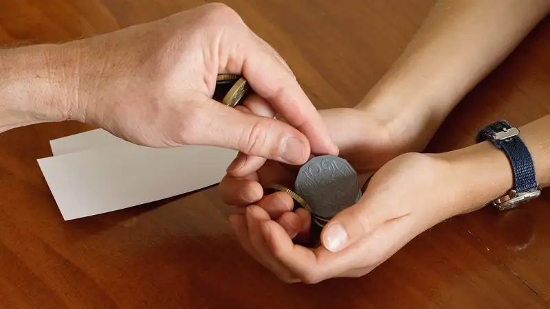 parent putting coins in child's hand