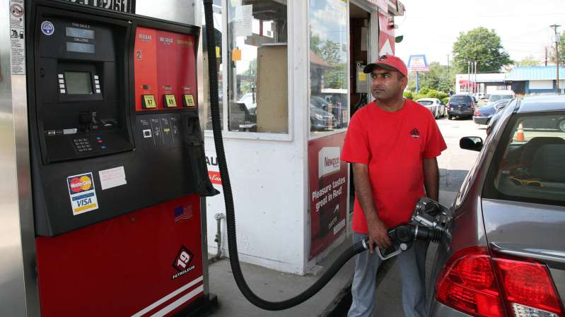 A gas attendant at a 19 Petroleum gas station pumps gas on August 25, 2015 in Woodbridge, New Jersey. Some places in New Jersey are seeing prices under two dollars as the price of gasoline continues to fall.