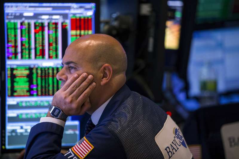 A trader looks at stock prices on a screen while working on the floor of the New York Stock Exchange shortly before the closing bell in New York August 26, 2015.