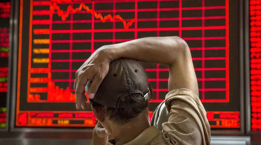 A Chinese day trader watches a stock ticker at a local brokerage house on August 27, 2015 in Beijing, China. A dramatic sell-off in Chinese stocks caused turmoil in markets around the world, driving indexes lower and erasing trillions of dollars in value.