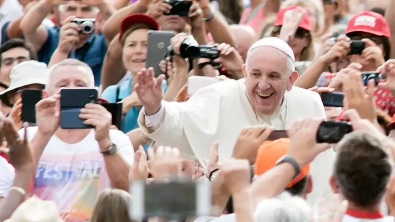 Pope Francis accompanied by his security agents, waves to faithful upon his arrival on St Peter's square at the Vatican to lead his weekly general audience on September 16, 2015.