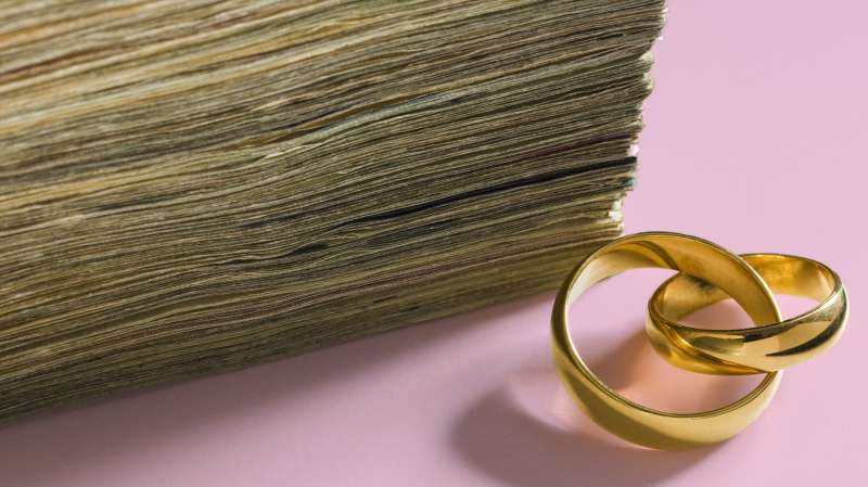 stack of cash and wedding rings
