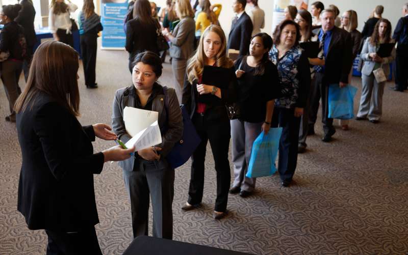 Jobseekers wait to talk to a recruiter (L) at the Colorado Hospital Association's health care career event in Denver October 13, 2014.