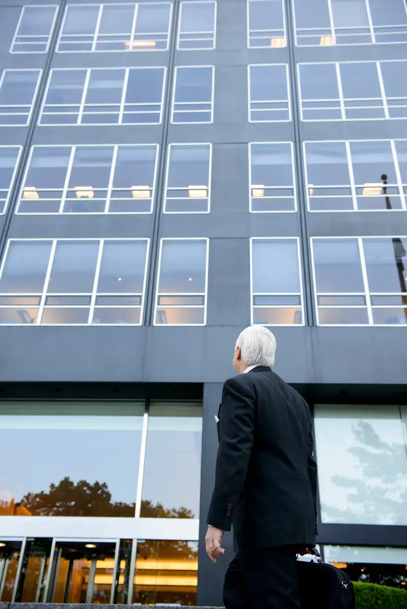 senior businessman walking into office building