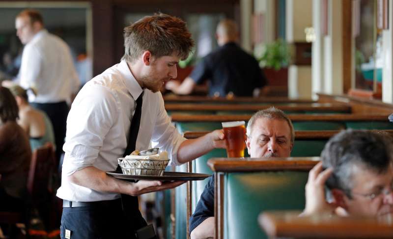 Waiter Spencer Meline serves a customer at Ivar's Acres of Clams restaurant on the Seattle waterfront, May 14, 2014.