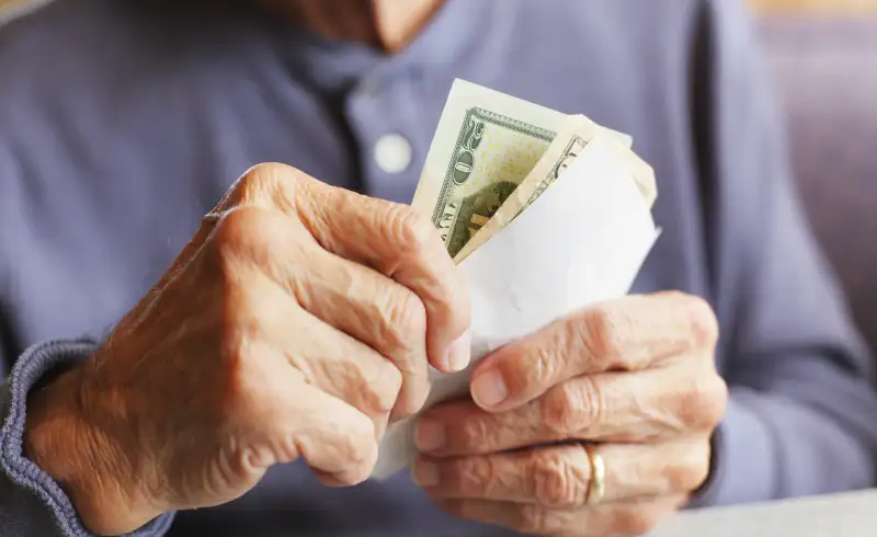 Senior adult with bill and money