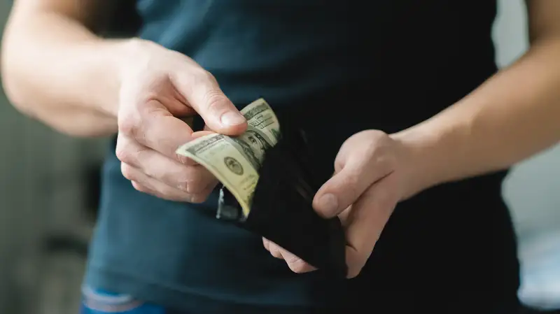 person pulling cash from wallet