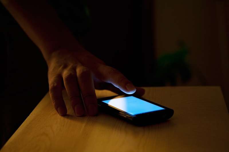 hand reaching for iPhone in the dark