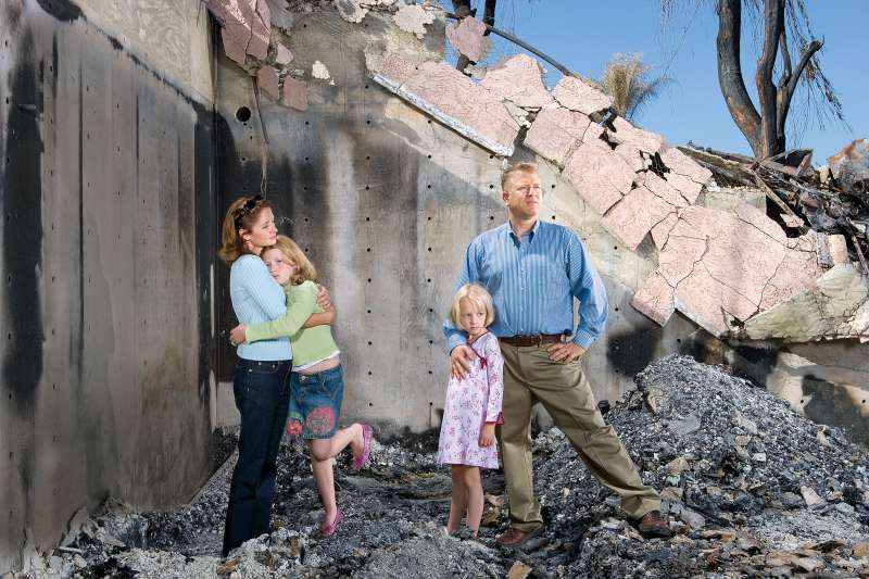 Nicole and Kevin Martin, with their daughters Emily (left) and Haley, stand in the ruins of their burnt-out home.