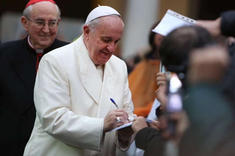Pope Francis signs an autograph as he visits Roman Parish of Sacro Cuore di Gesu on January 19, 2014.