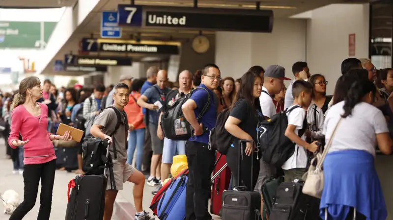 Passengers wait in long lines at the United Airlines terminal at LAX in the morning after a nation-wide flight stoppage July 8, 2015 in Los Angeles, California.