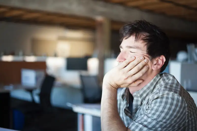 person with eyes closed in office