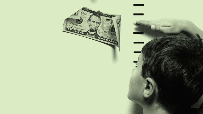 little boy measuring height with money