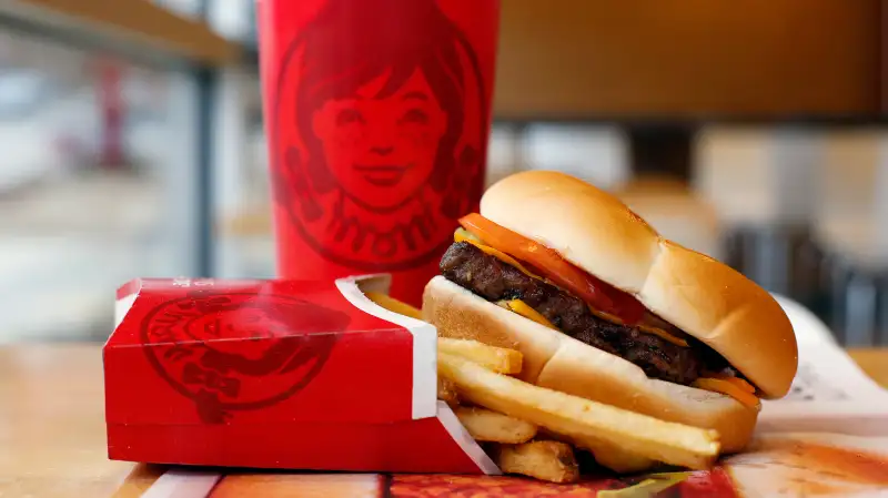 A Wendy's single hamburger with cheese, fries and a drink at a Wendy's restaurant in Pittsburgh