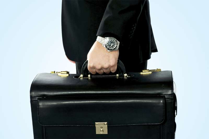 hand with watch holding briefcase