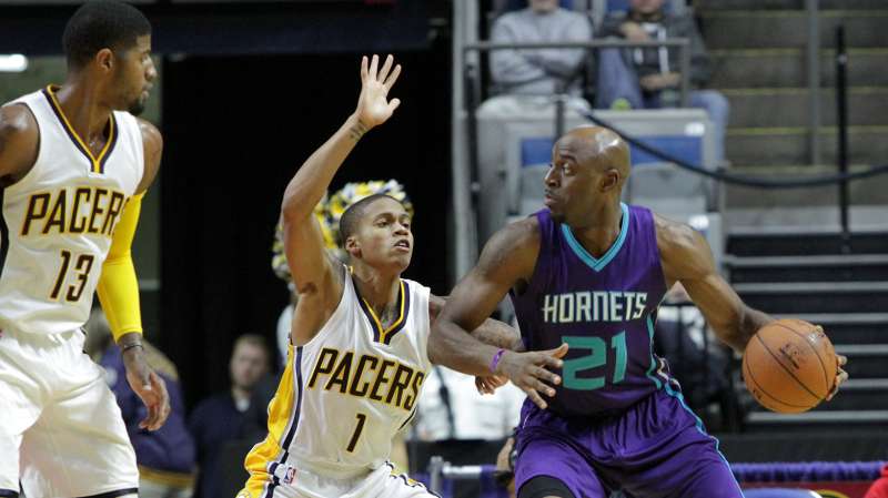 Damien Wilkins #21 of the Charlotte Hornets handles the ball against Joseph Young #1 of the Indiana Pacers on October 22, 2015 at Allen County War Memorial Coliseum in Fort Wayne, Indiana.