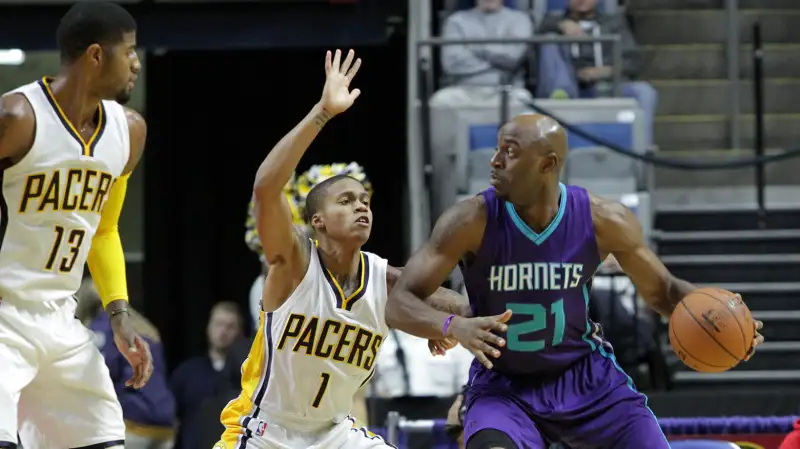 Damien Wilkins #21 of the Charlotte Hornets handles the ball against Joseph Young #1 of the Indiana Pacers on October 22, 2015 at Allen County War Memorial Coliseum in Fort Wayne, Indiana.