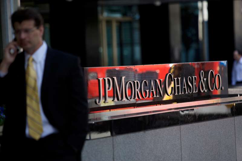 A man on a mobile phone walks by the offices of JPMorgan Chase & Co. in New York, on May 17, 2013.
