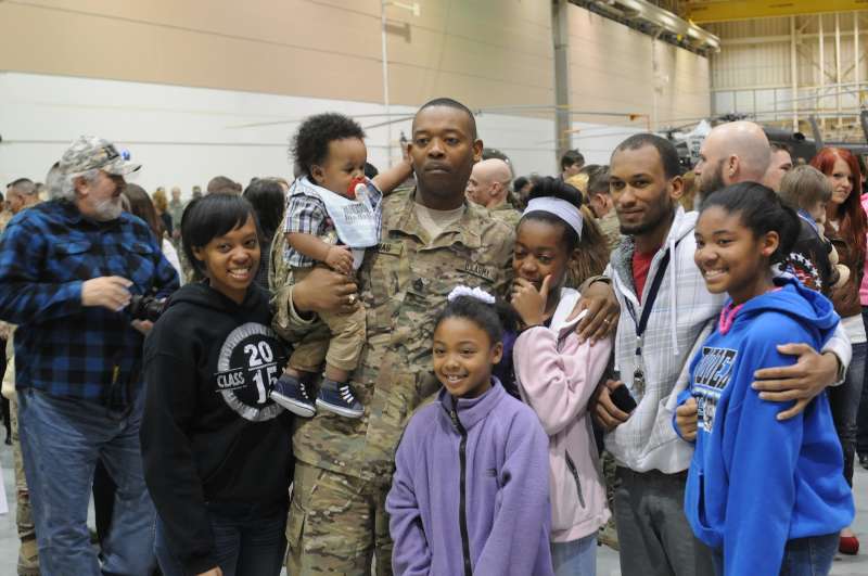 U.S. Army Sgt. 1st Class Ricky Thomas, 4th Brigade Special Troops Battalion, 4th Brigade Combat Team, 10th Mountain Division, poses for a picture with his family after returning to Fort Polk from Afghanistan February 11, 2014.