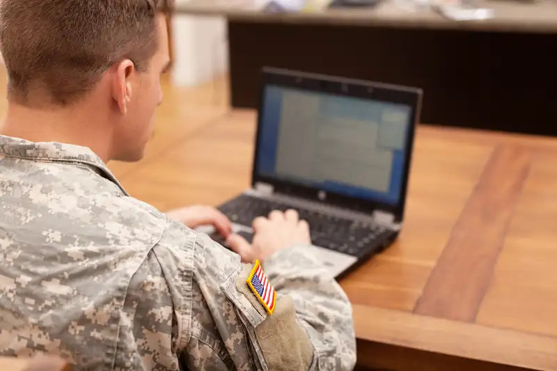 Man in Army uniform using computer