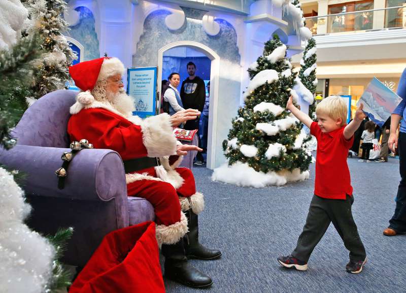 John Doris, age 4, stretches out his arms to hug Santa, at the Ice Palace inside Cherry Creek Mall, in Denver, November 29, 2013.