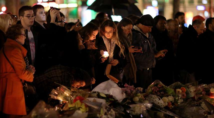 People light candles at a makeshift memorial at the place de la republique on November 17, 2015 in Paris, France. Paris remains under heightened security following terrorist attacks , which left at least 129 people dead and hundreds more injured.