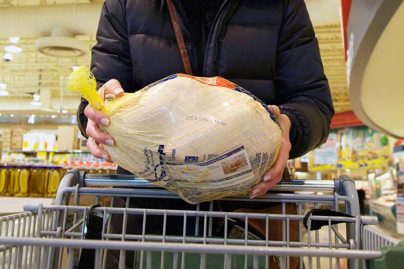 woman holding turkey in grocery store