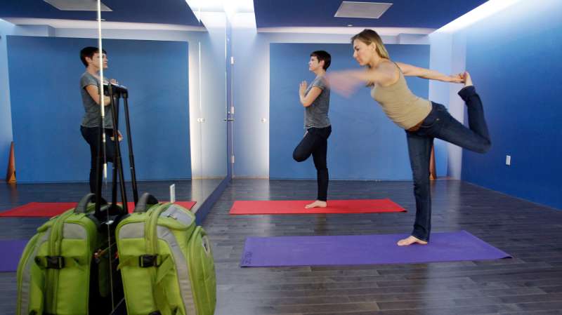 In this January 27, 2012 photo, travelers Maria Poole, right, and Lindsey Shepard, practice yoga at San Francisco International Airport's new Yoga Room, in San Francisco. The quiet, dimly lit studio officially opened last week in a former storage room just past the security checkpoint at SFO's Terminal 2. Airport officials believe the 150-square-foot room with mirrored walls is the world's first airport yoga studio, said spokesman Mike McCarron.