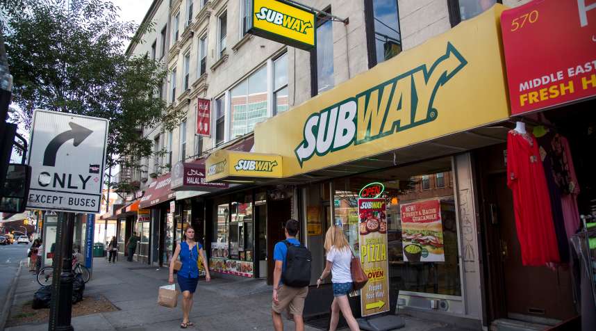 Pedestrians pass a Subway restaurant on Atlantic Avenue in Brooklyn.
