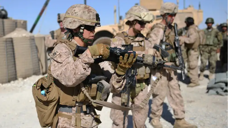 Members of Female Engagement Team (FET), US Marines GySgt Michelle Hill (L) and Cpl. Reagan Odhner (C) from the 1st battalion 7th Marines Regiment unload their M4 rifles after a patrol with Afghanistan National Army (ANA) soldiers in Sangin in Helmand Province on June 6, 2012.