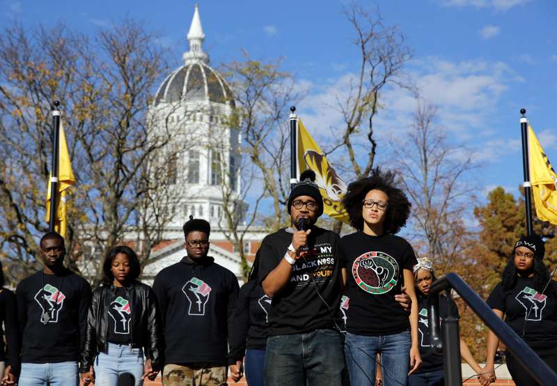 In this November 9, 2015, fphoto, graduate student Jonathan Butler, center, addresses a crowd following the announcement that University of Missouri System President Tim Wolfe would resign, in Columbia, Mo. On the day he met with black players for the University of Missouri’s football team, Butler hadn’t eaten for six days.