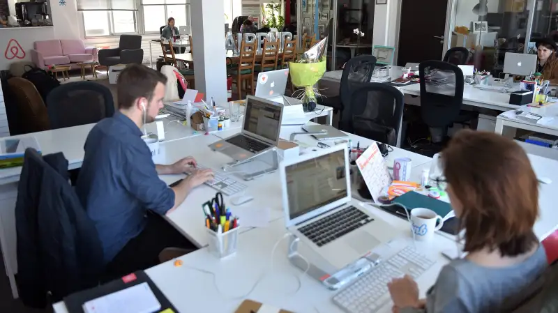 Employees of online lodging service Airbnb work in the Airbnb offices in Paris on April 21, 2015.