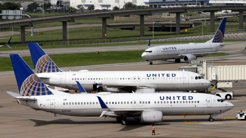 In this July 8, 2015 photo, a United Airlines plane, front, is pushed back from a gate at George Bush Intercontinental Airport in Houston.