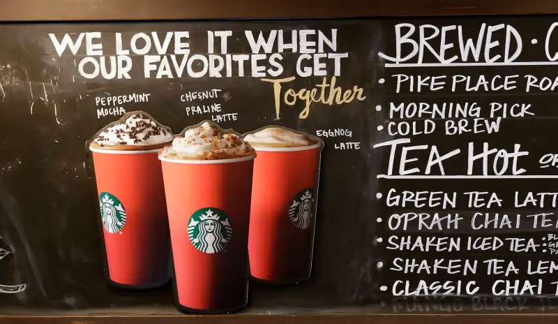 Red paper cups are featured on a chalkboard menu behind the counter at a Starbucks coffee shop in the Pike Place Market, November 10, 2015, in Seattle.