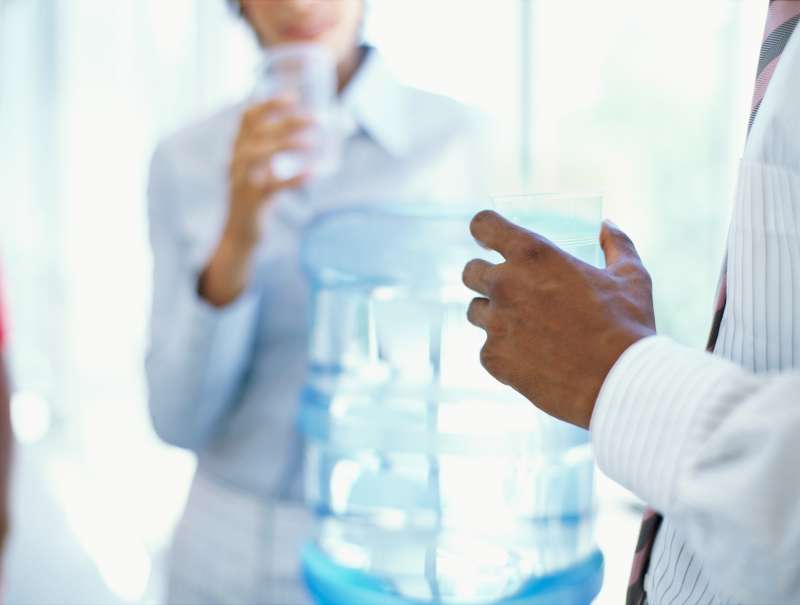 businessman and a businesswoman drinking water in an office