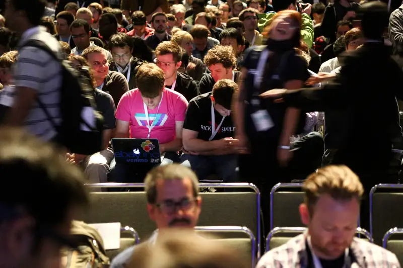 A Google I/O 2014 attendee uses his laptop as people file in for the keynote speech at the Google I/O developers conference in San Francisco, June 25, 2014.