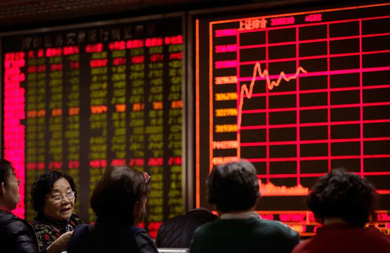 Women chat with each other in front of an electronic board displaying stock prices at a brokerage house in Beijing, January 5, 2016. Last year’s Chinese stock boom and disastrous bust has left a legacy of public distrust of financial markets along with a bill the ruling party has yet to disclose for its rescue. The Shanghai index ended 2015 up 9.5 percent for the year, compared with a 0.7 percent loss for Wall Street’s Standard & Poor’s 500 index. But many novices who bought just before the peak are left with shares worth less than they cost.