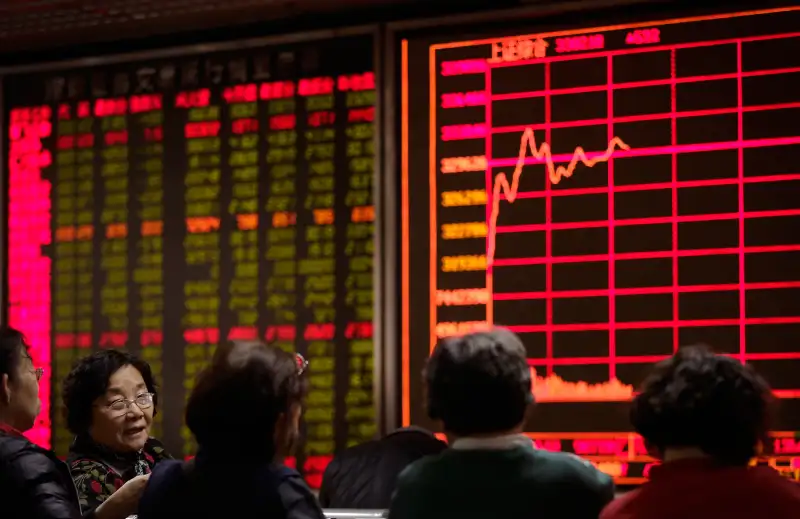 Women chat with each other in front of an electronic board displaying stock prices at a brokerage house in Beijing, January 5, 2016. Last year’s Chinese stock boom and disastrous bust has left a legacy of public distrust of financial markets along with a bill the ruling party has yet to disclose for its rescue. The Shanghai index ended 2015 up 9.5 percent for the year, compared with a 0.7 percent loss for Wall Street’s Standard & Poor’s 500 index. But many novices who bought just before the peak are left with shares worth less than they cost.