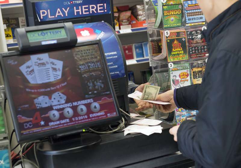 A man purchases a Powerball lottery ticket at a liquor store in Washington, DC, January 4, 2016.