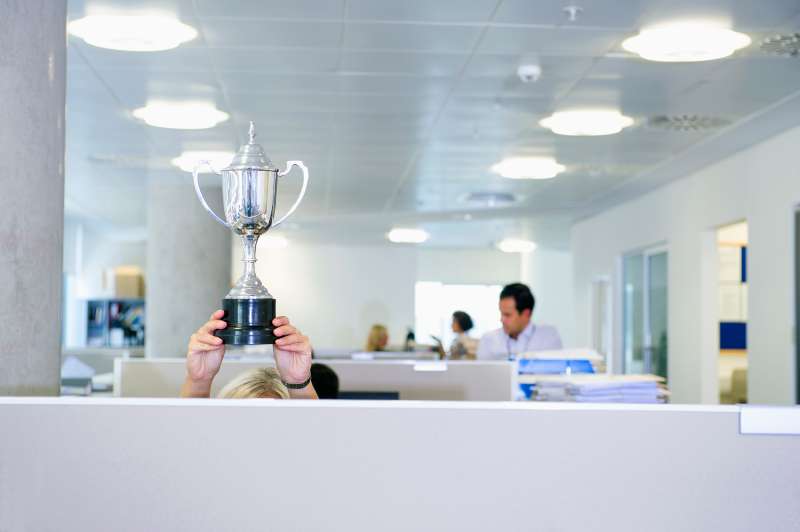 woman holding trophy in office