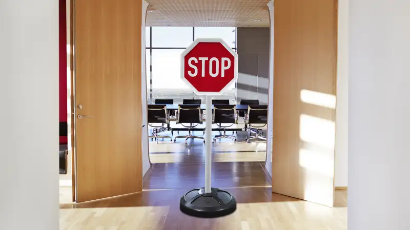 stop sign in front of the doors to a meeting room