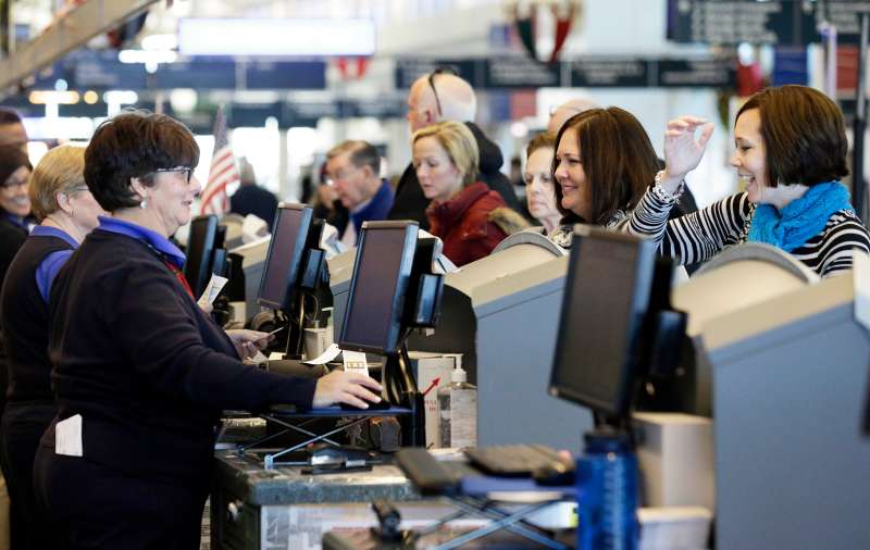 Travelers check tickets and their bags with check in counters at Midway International Airport in Chicago.