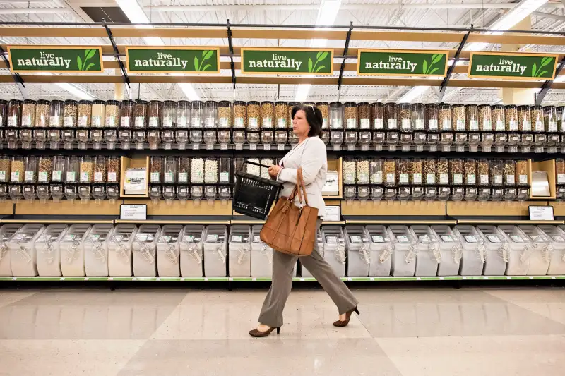 A customer walks past bulk food bins at a Kroger Co. store in Peoria, Illinois, U.S.