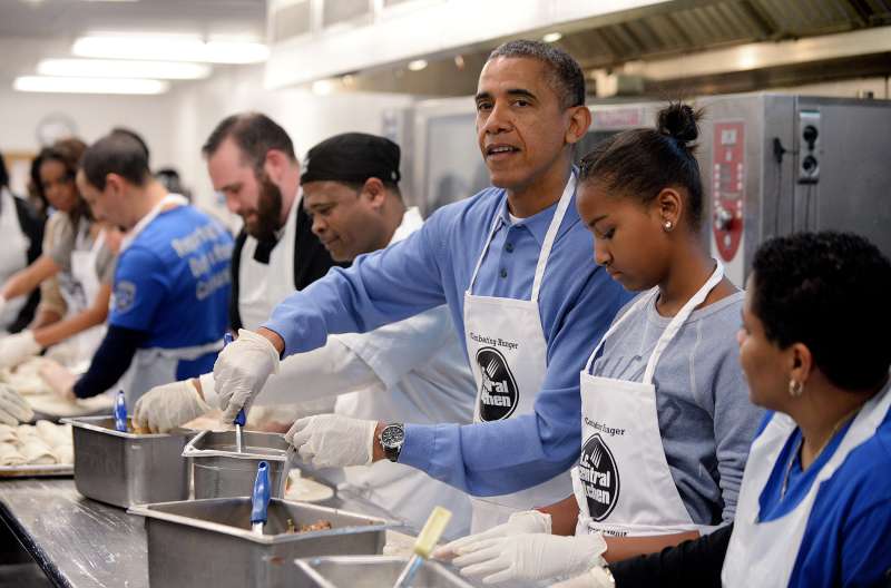 U.S. President Barack Obama with daughter Sasha and First Lady Michelle Obama (L) participate in a community service project at the D.C Central Kitchen in celebration of the Martin Luther King, Jr. Day of Service and in honor of Dr. King's life and legacy on January 20, 2014 in Washington, DC. Americans honor the birth of civil rights leader Martin Luther King, Jr.