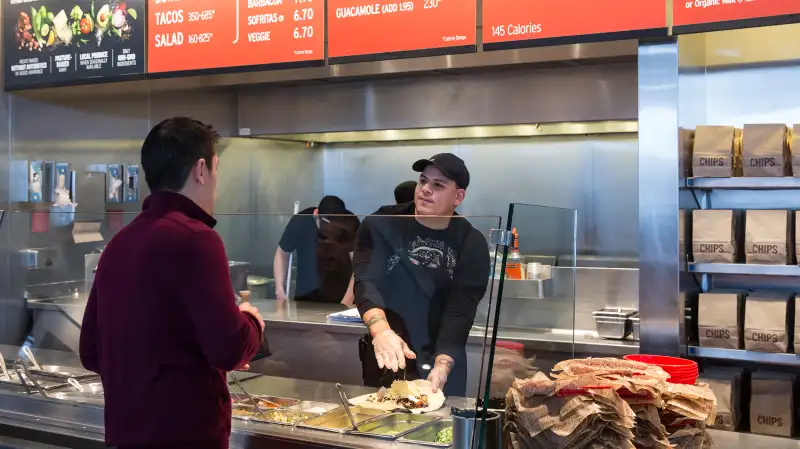 A Chipotle Mexican Grill employee prepares a burrito for a customer on December 15, 2015, in Seattle.