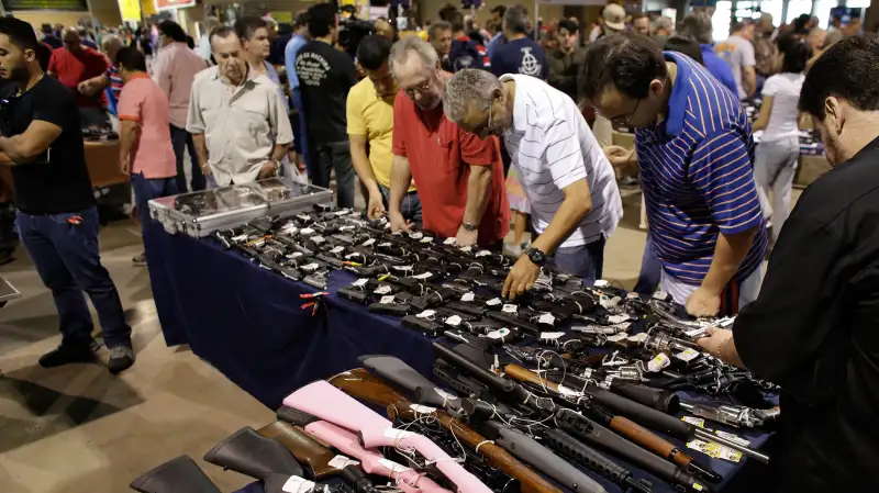 People shop for guns at a gun show hosted by Florida Gun Shows, January 9, 2016, in Miami. Schlesinger purchased an Uzi and a Smith & Wesson 38.