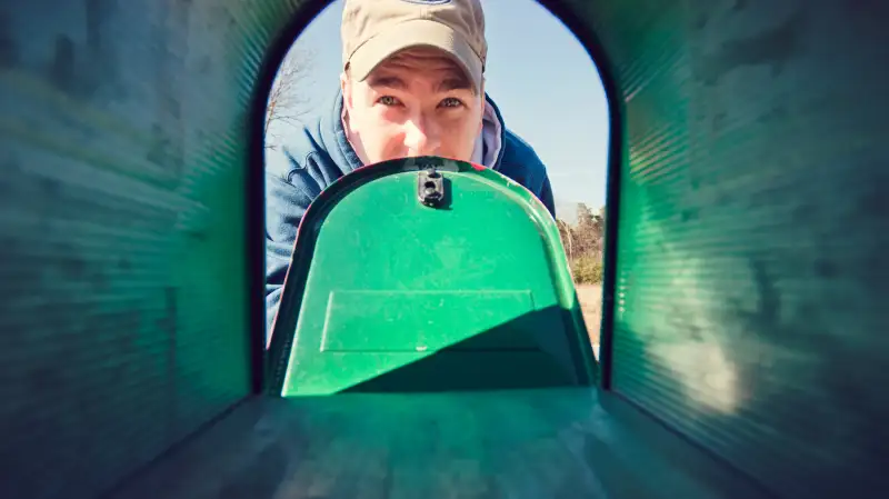 man looking in mailbox