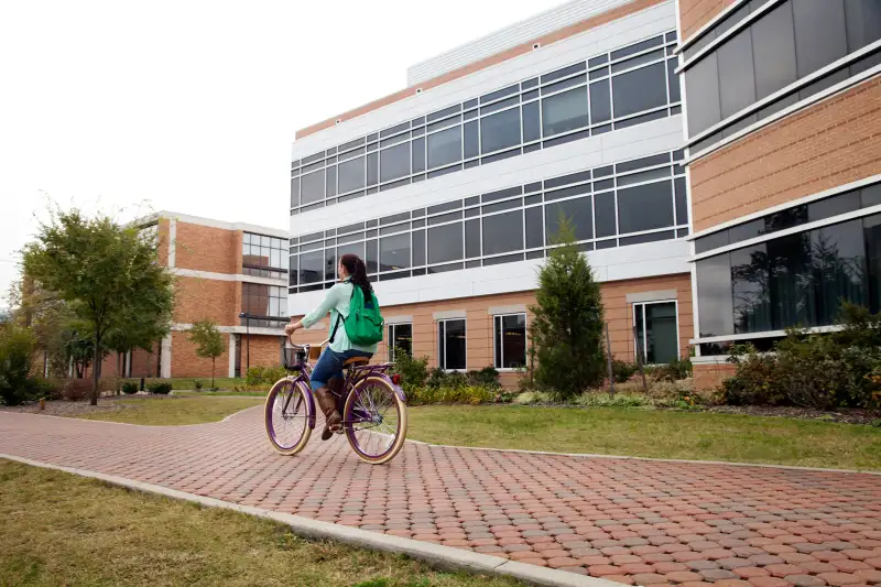 girl riding bicycle on campus