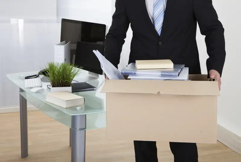 man carrying box out of office